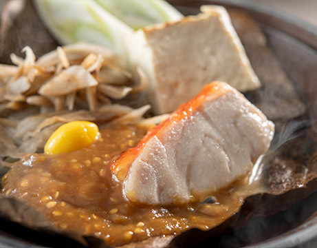 Grilled red snapper on a porcelain plate with leeks and miso paste